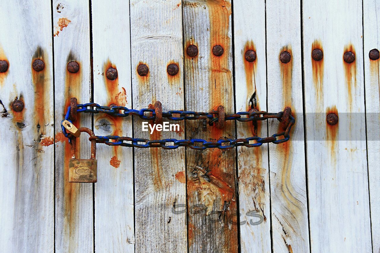 Close-up of chain on closed wooden door