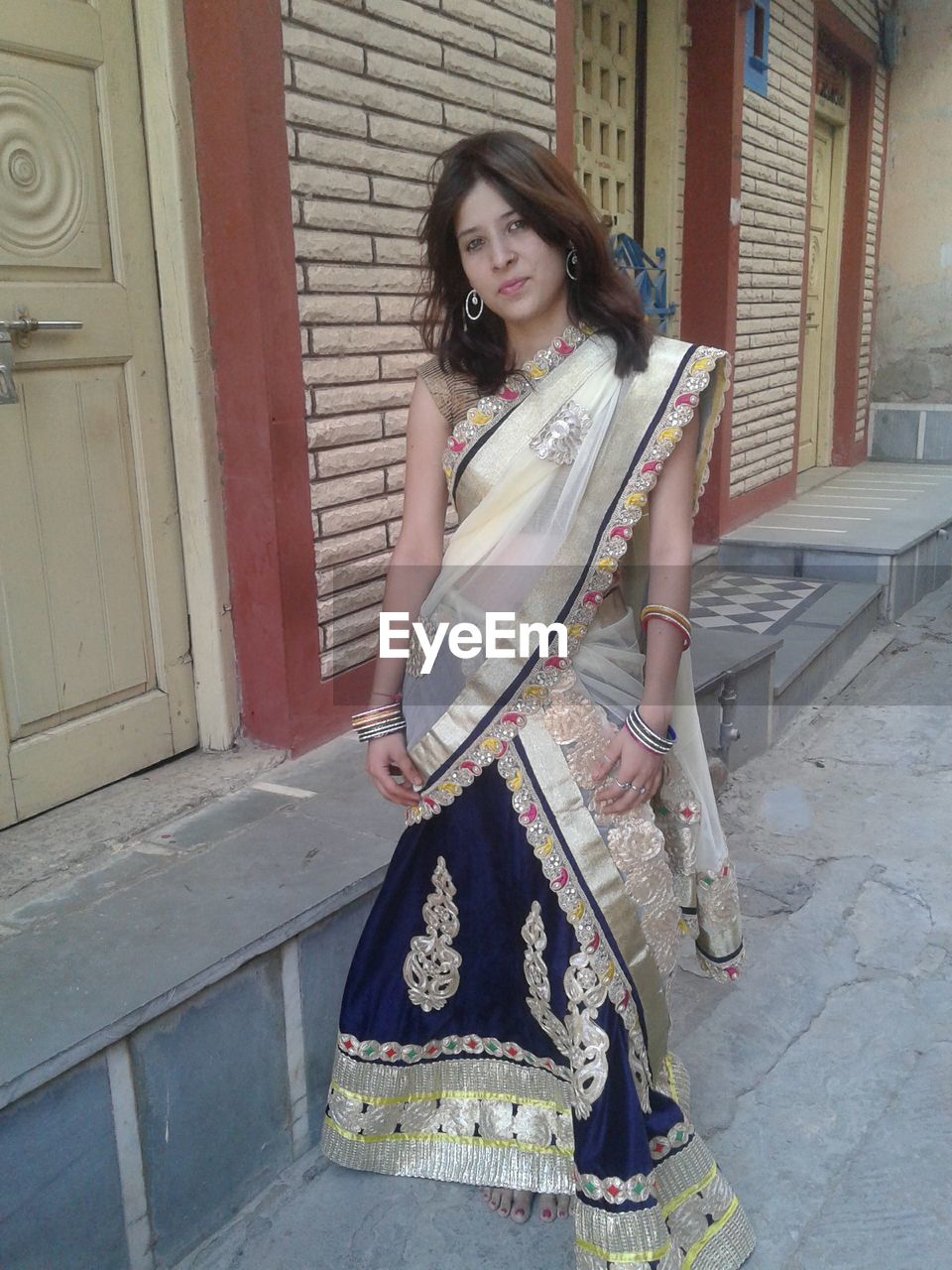 Portrait of woman wearing sari and standing against building