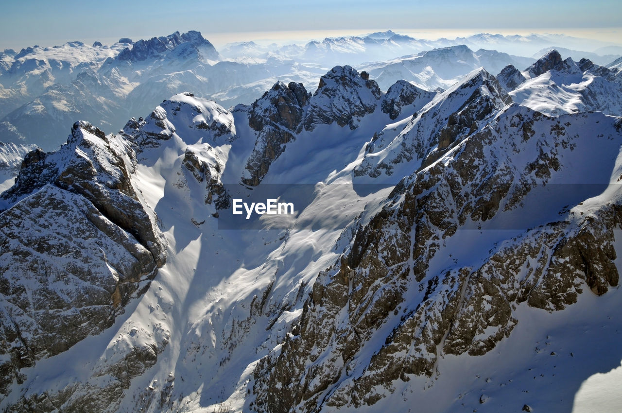 Scenic view of snow mountains against blue sky