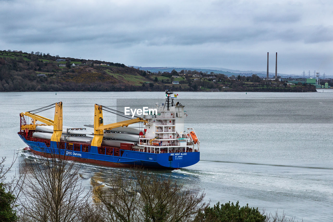 BOAT MOORED IN SEA AGAINST SKY