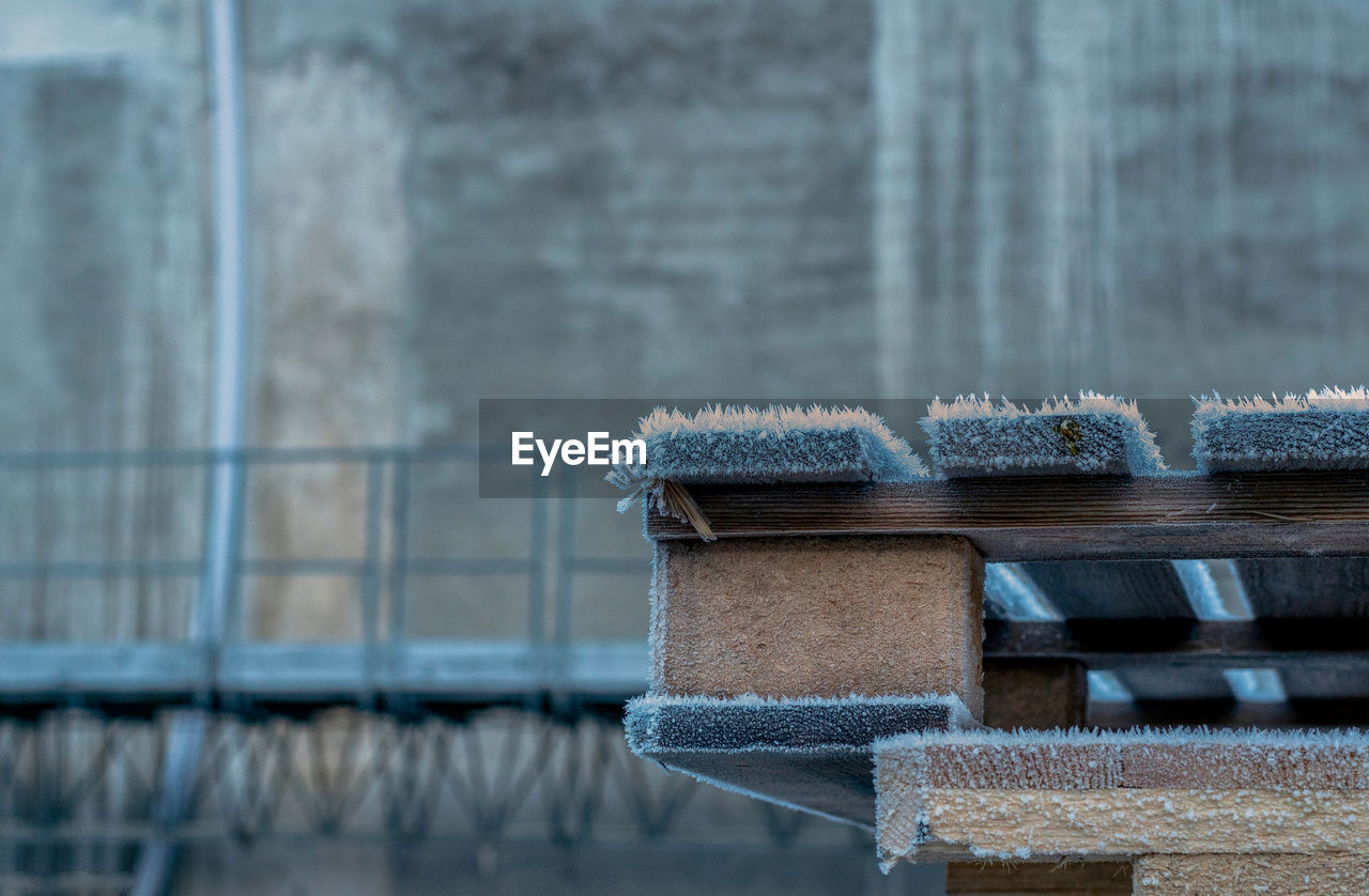 CLOSE-UP OF FROZEN ICE ON WOOD AGAINST BLURRED BACKGROUND