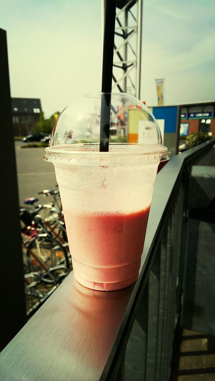 Smoothie in disposable cup on railing