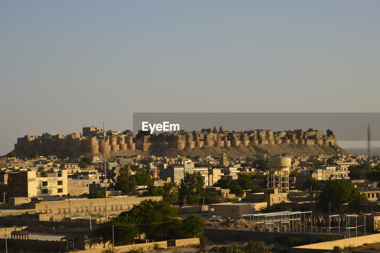 Houses in city against clear sky