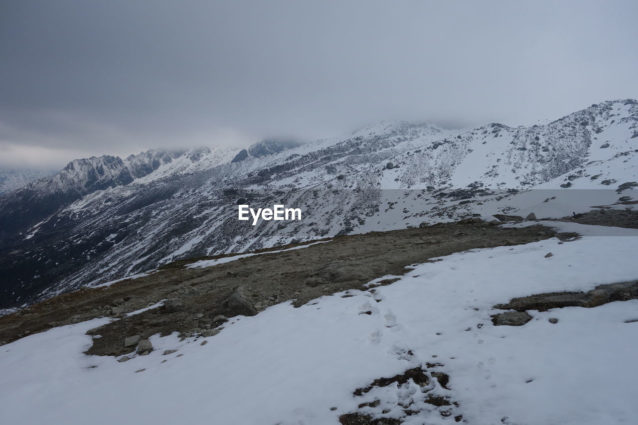 SNOW COVERED MOUNTAINS AGAINST SKY