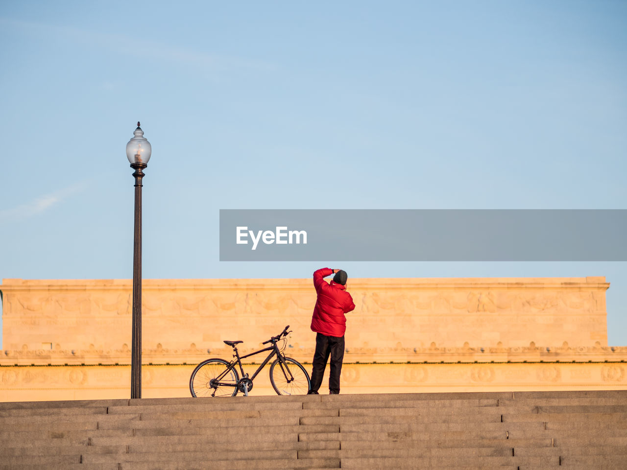 REAR VIEW OF MAN RIDING BICYCLE