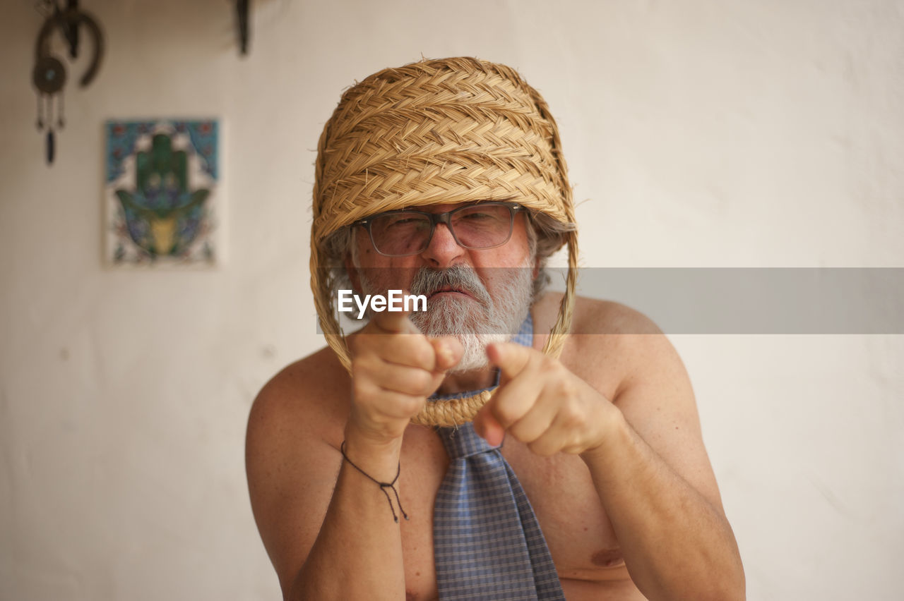 FULL LENGTH PORTRAIT OF MAN HOLDING HAT