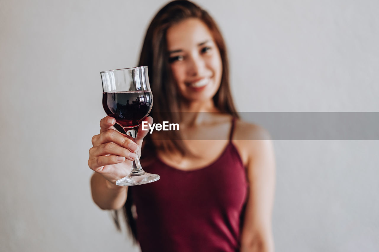 PORTRAIT OF YOUNG WOMAN DRINKING GLASS WITH DRINK