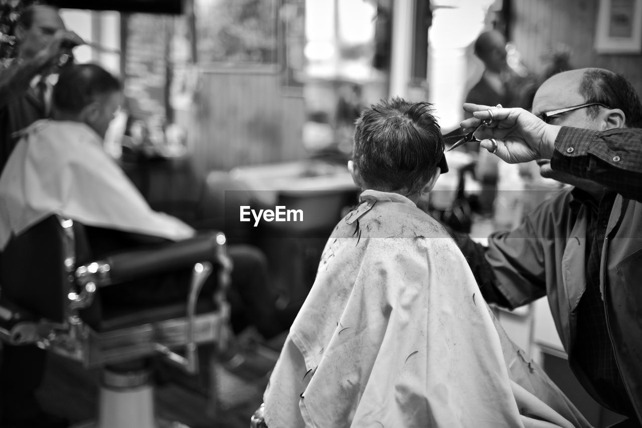 Barber cutting hair of boy