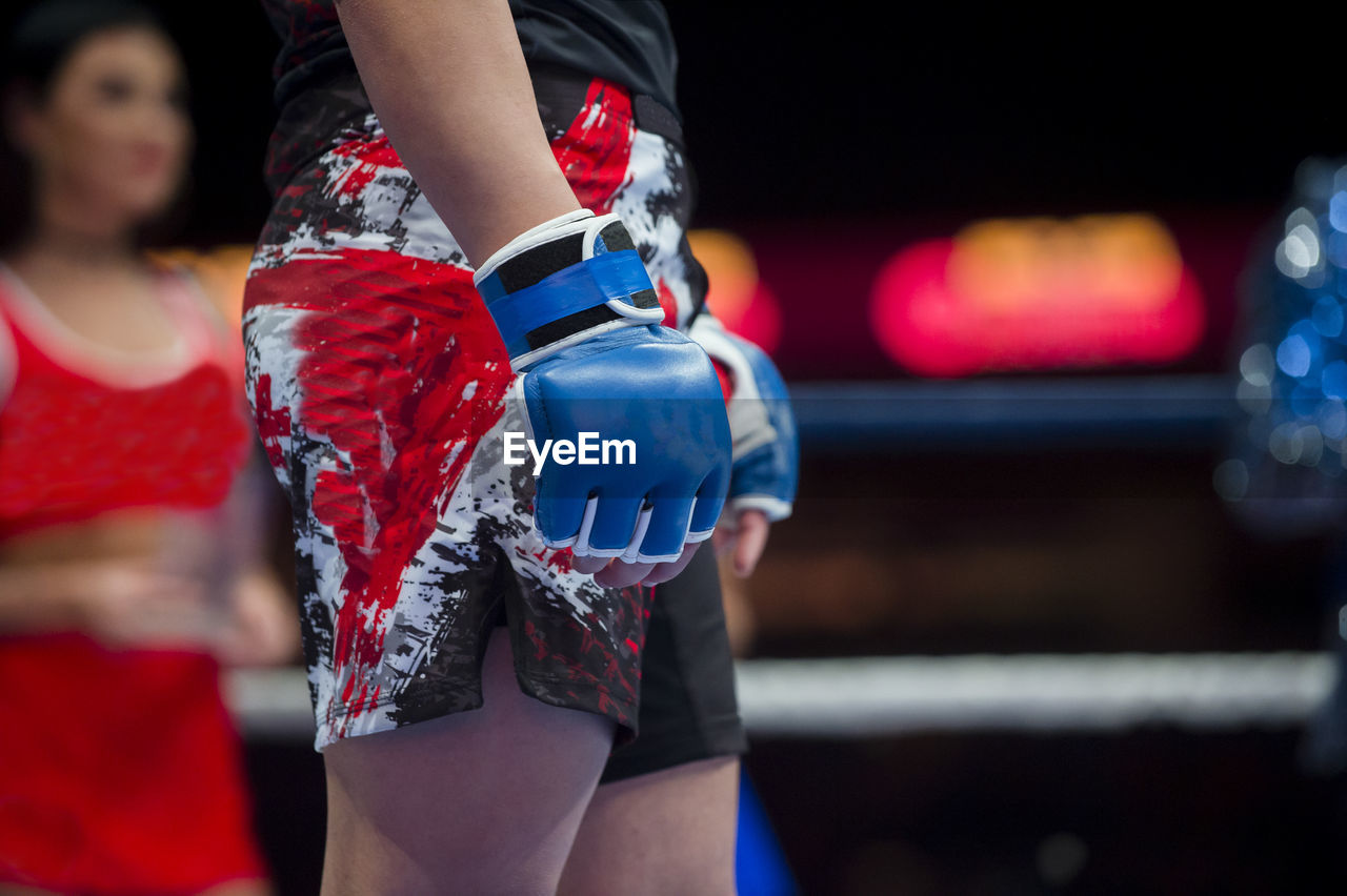 Midsection of shirtless boxer standing in boxing ring