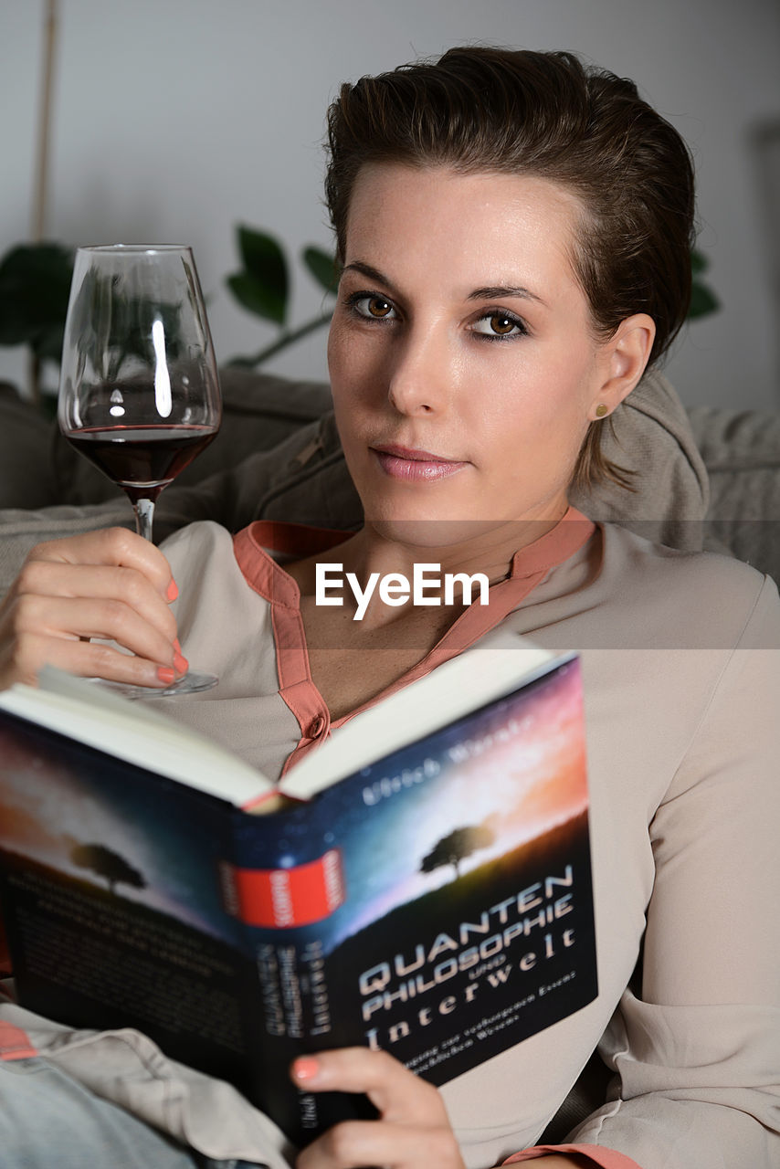 PORTRAIT OF SMILING WOMAN HOLDING GLASS