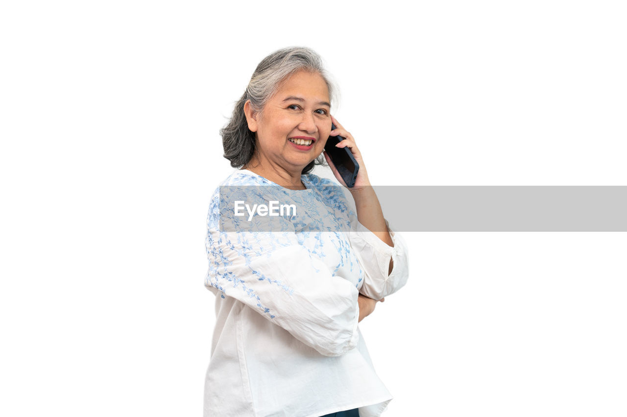 WOMAN STANDING AGAINST WHITE BACKGROUND