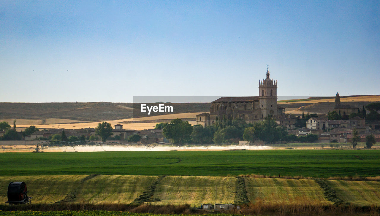 Scenic view of field and cathedral against clear sky