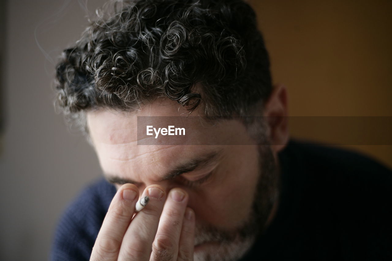 Close-up of man holding cigarette