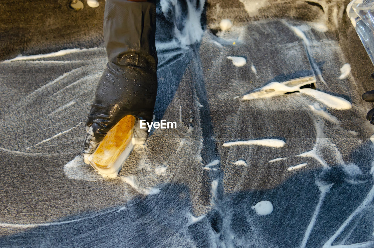 Cropped hand of man cleaning car in garage