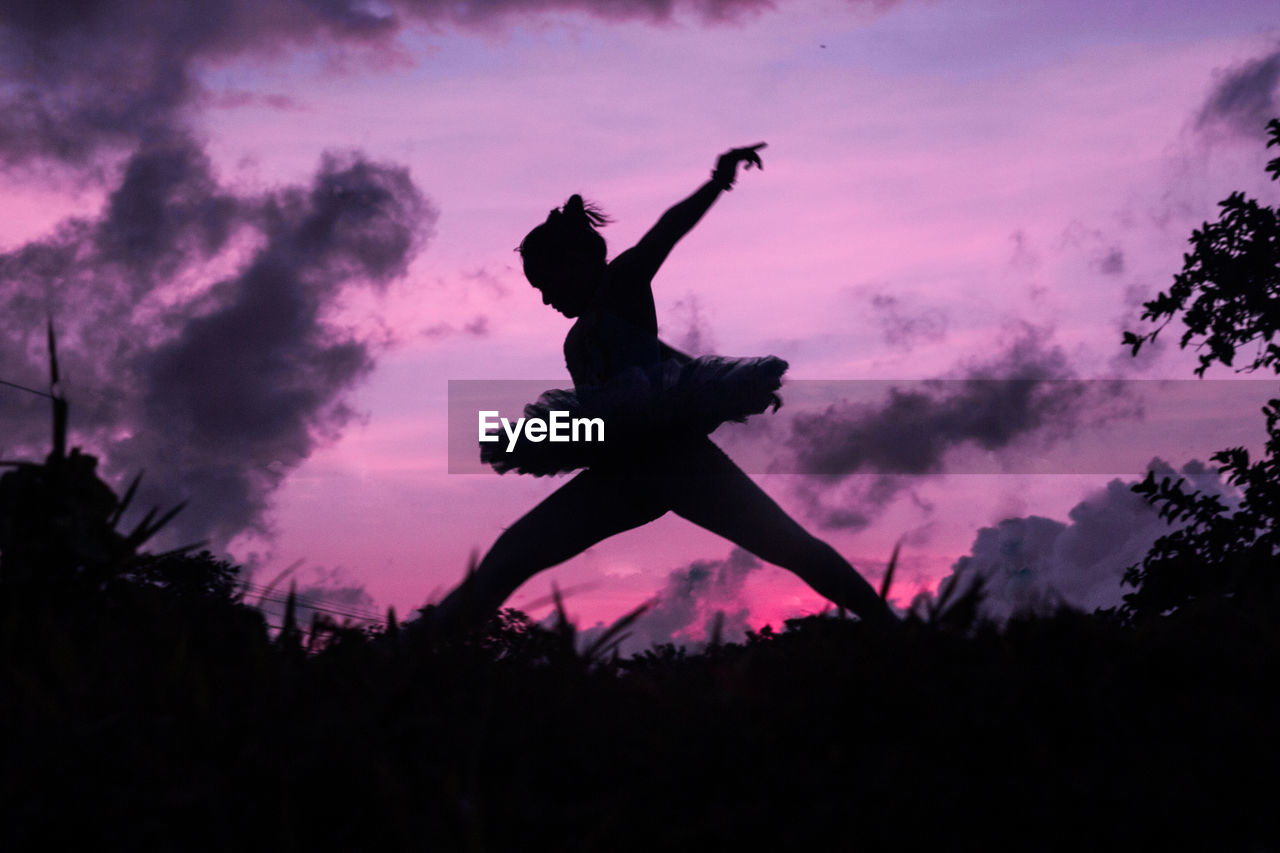 Silhouette teenage girl dancing ballet on field against sky