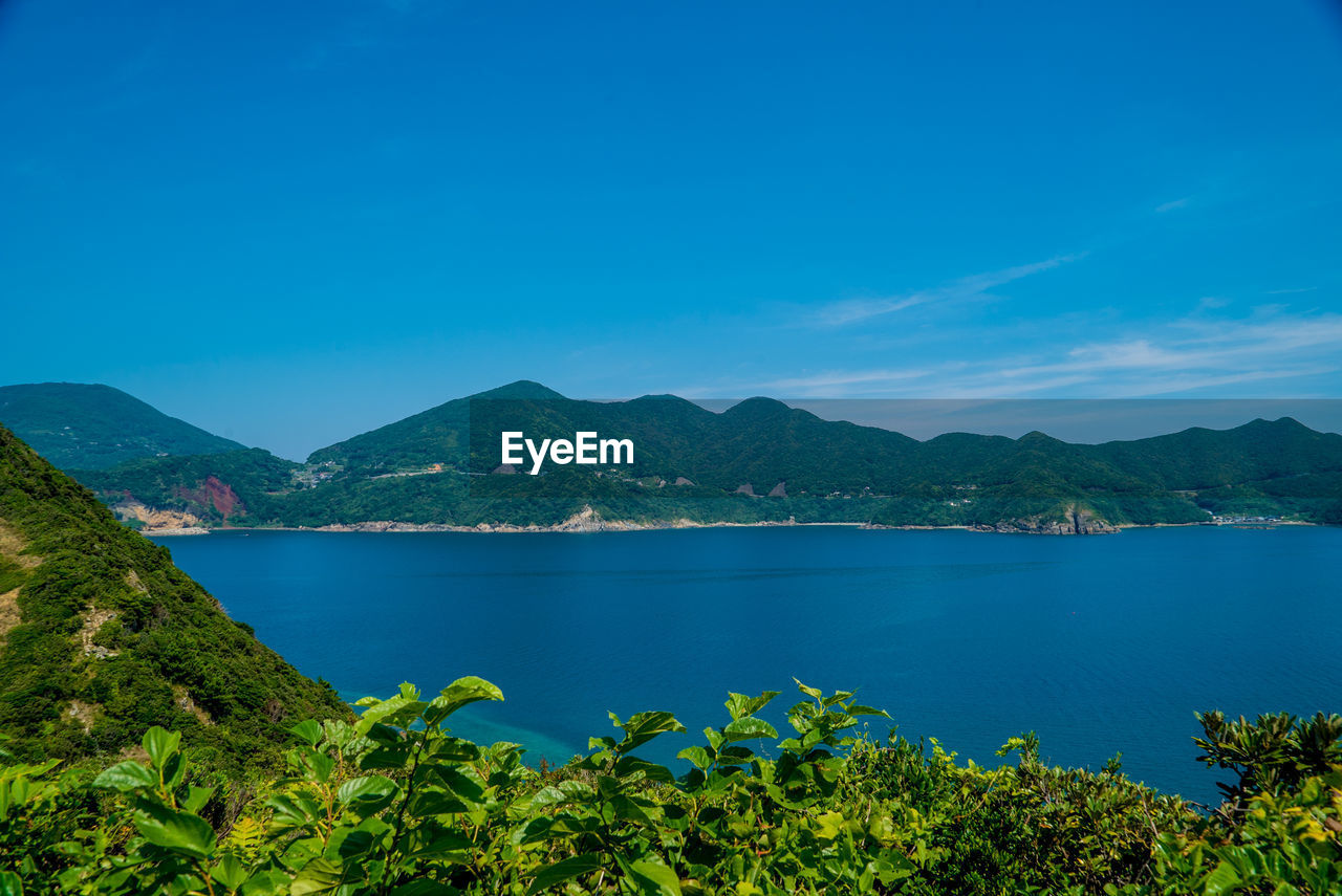 Scenic view of bay against blue sky