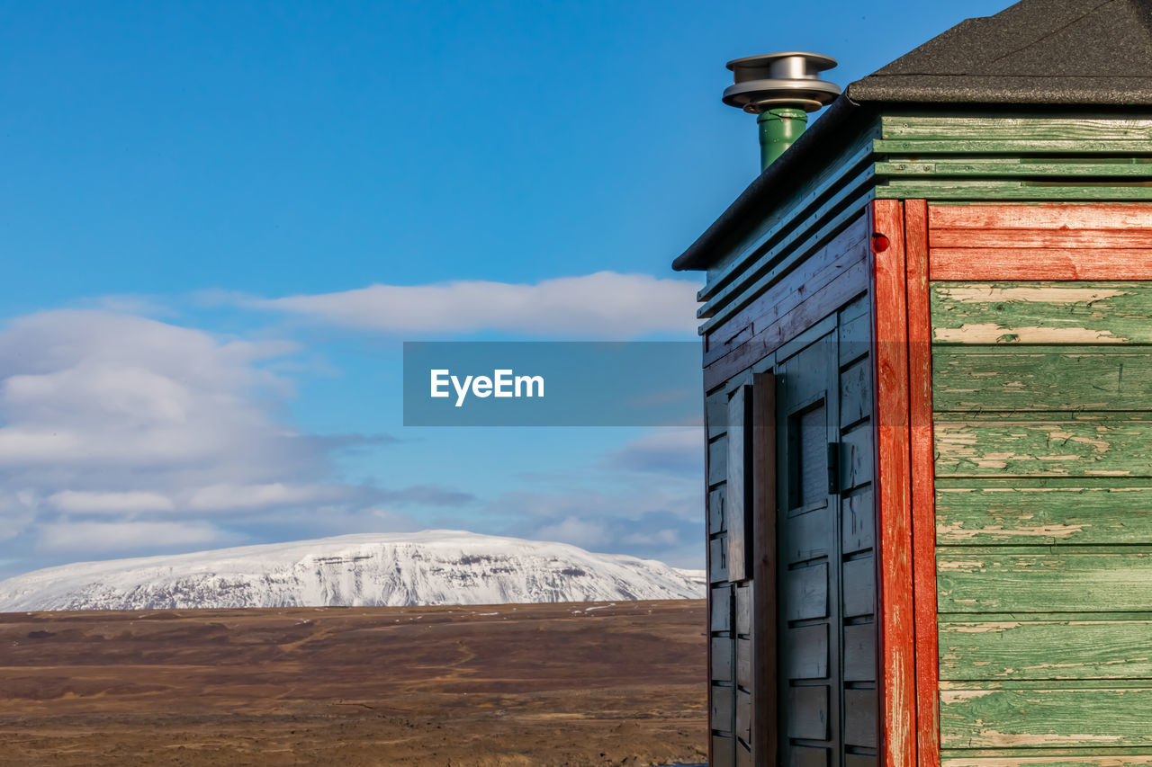 HOUSE ON MOUNTAIN AGAINST SKY