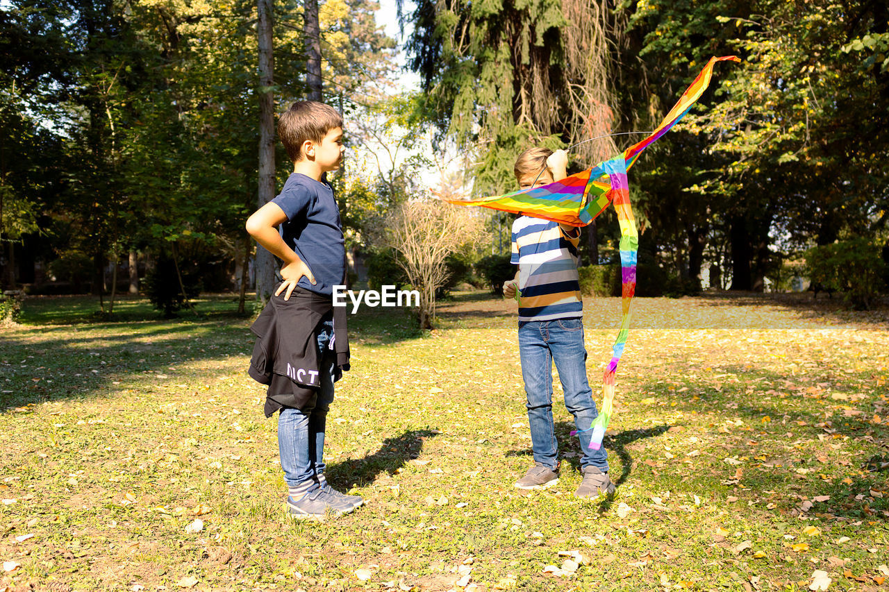 Full length of boys playing with kite at park