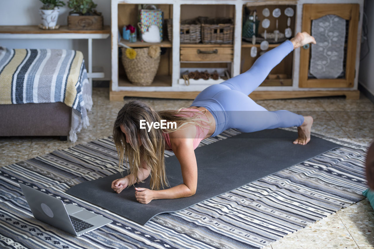 WOMAN LYING ON FLOOR AT HOME