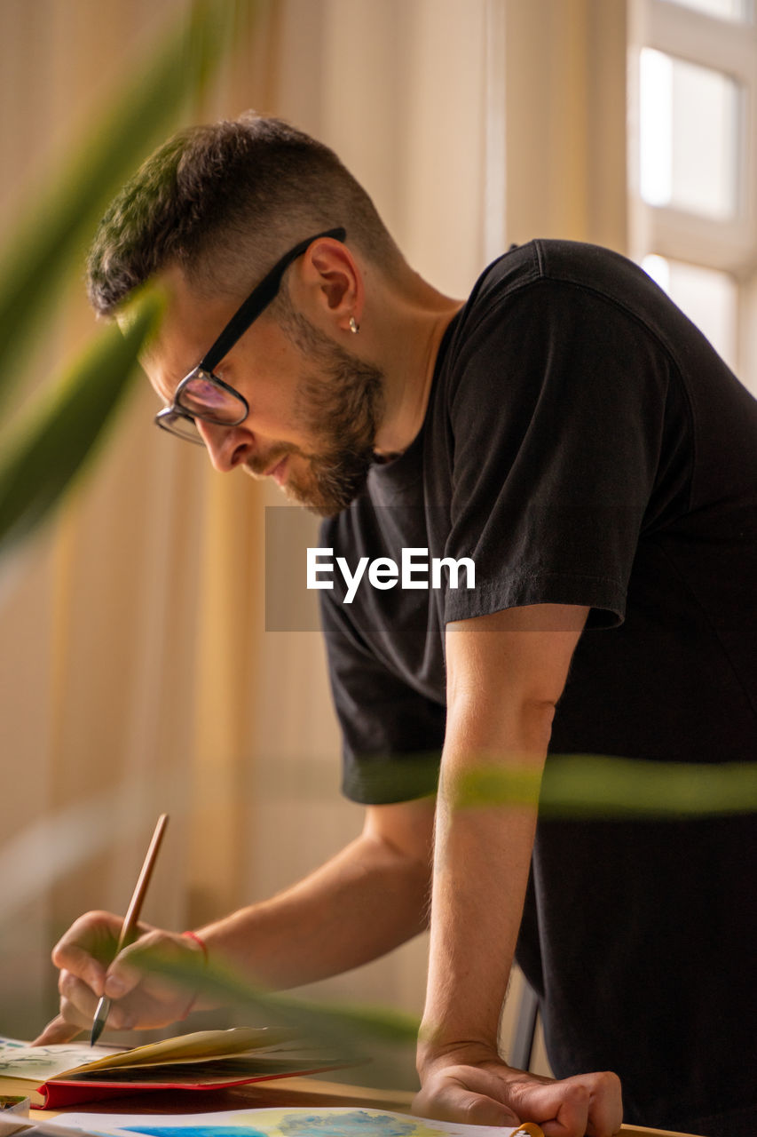 Midsection of young man holding eyeglasses