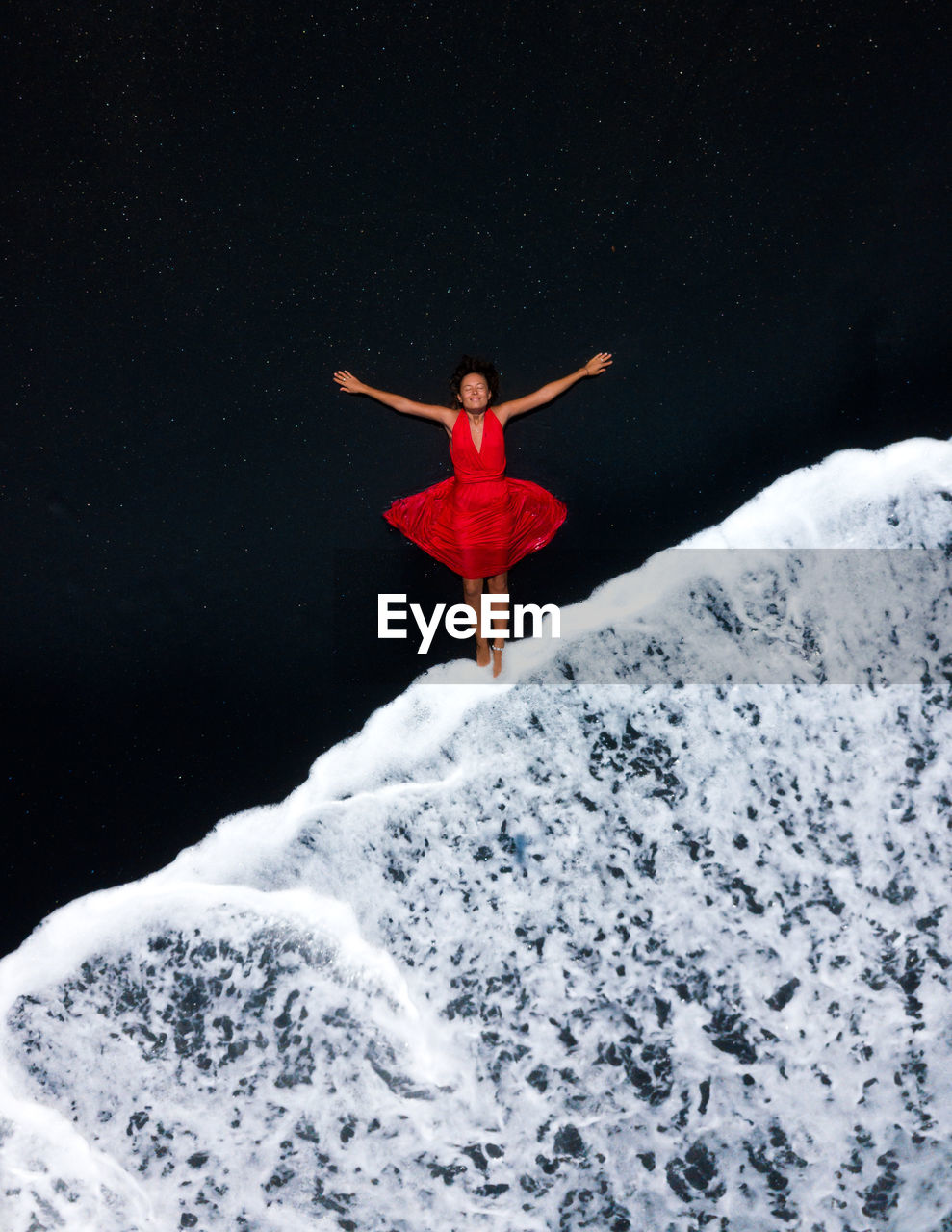 Aerial view of young woman lying down on shore