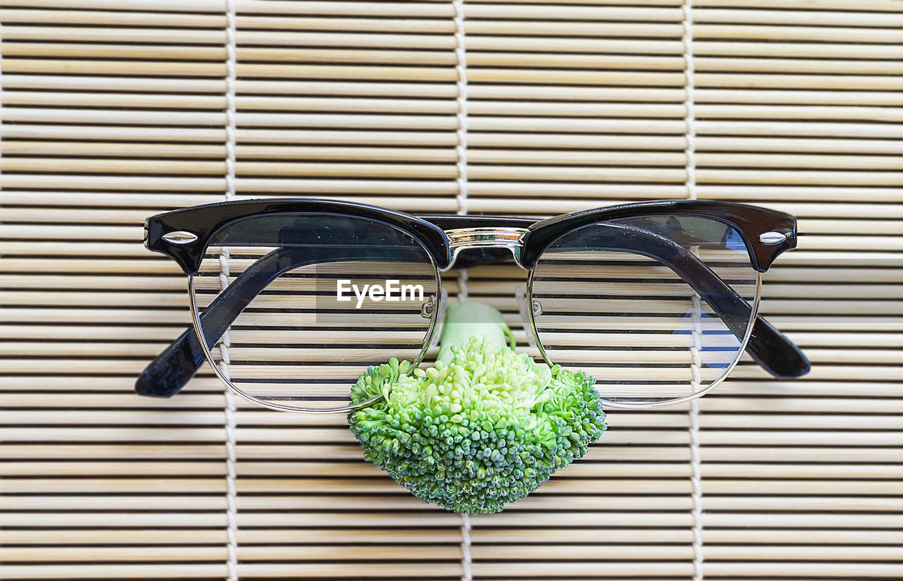 Close-up of anthropomorphic face made with eyeglasses and broccoli on place mat