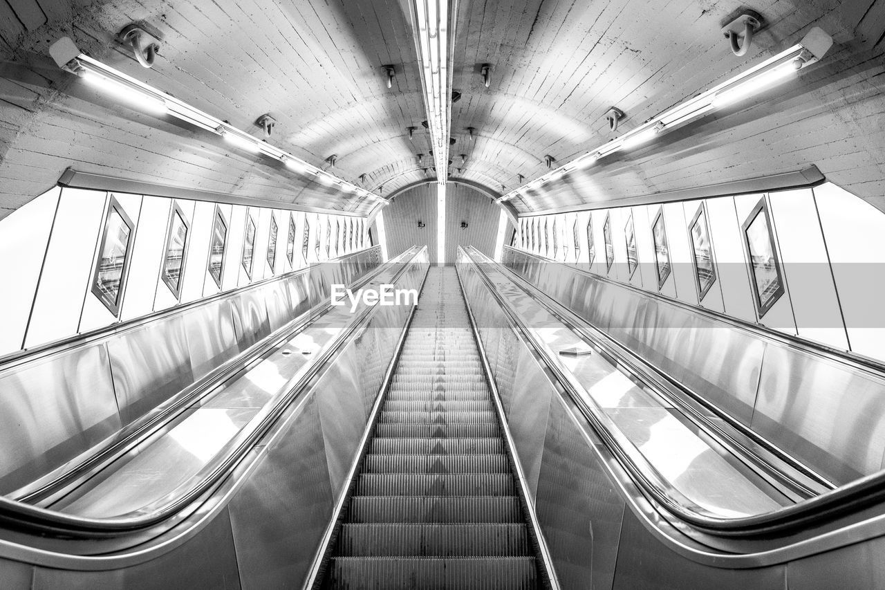 VIEW OF ESCALATOR IN ILLUMINATED UNDERGROUND