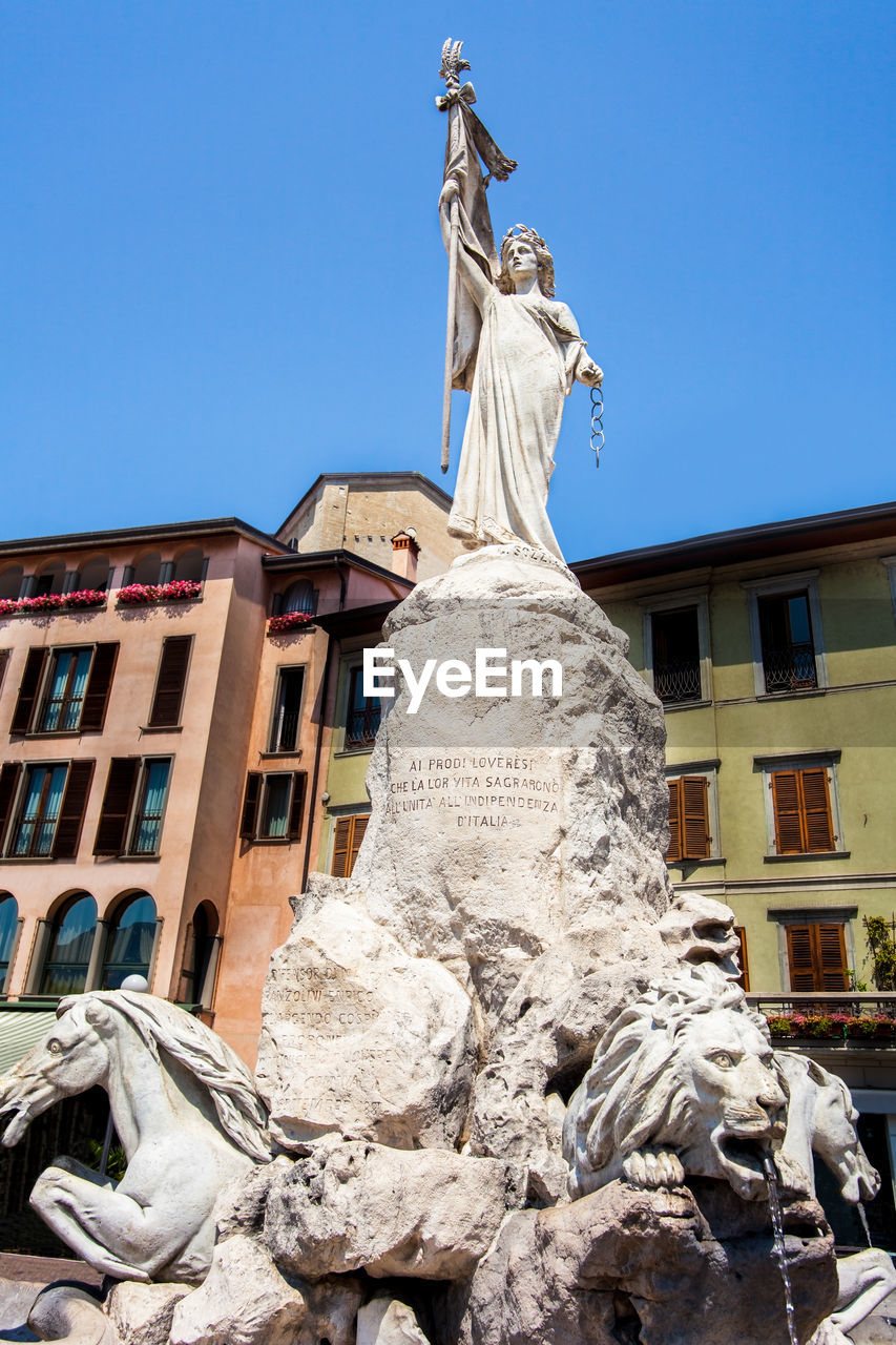 LOW ANGLE VIEW OF STATUES AGAINST BUILDING AGAINST SKY