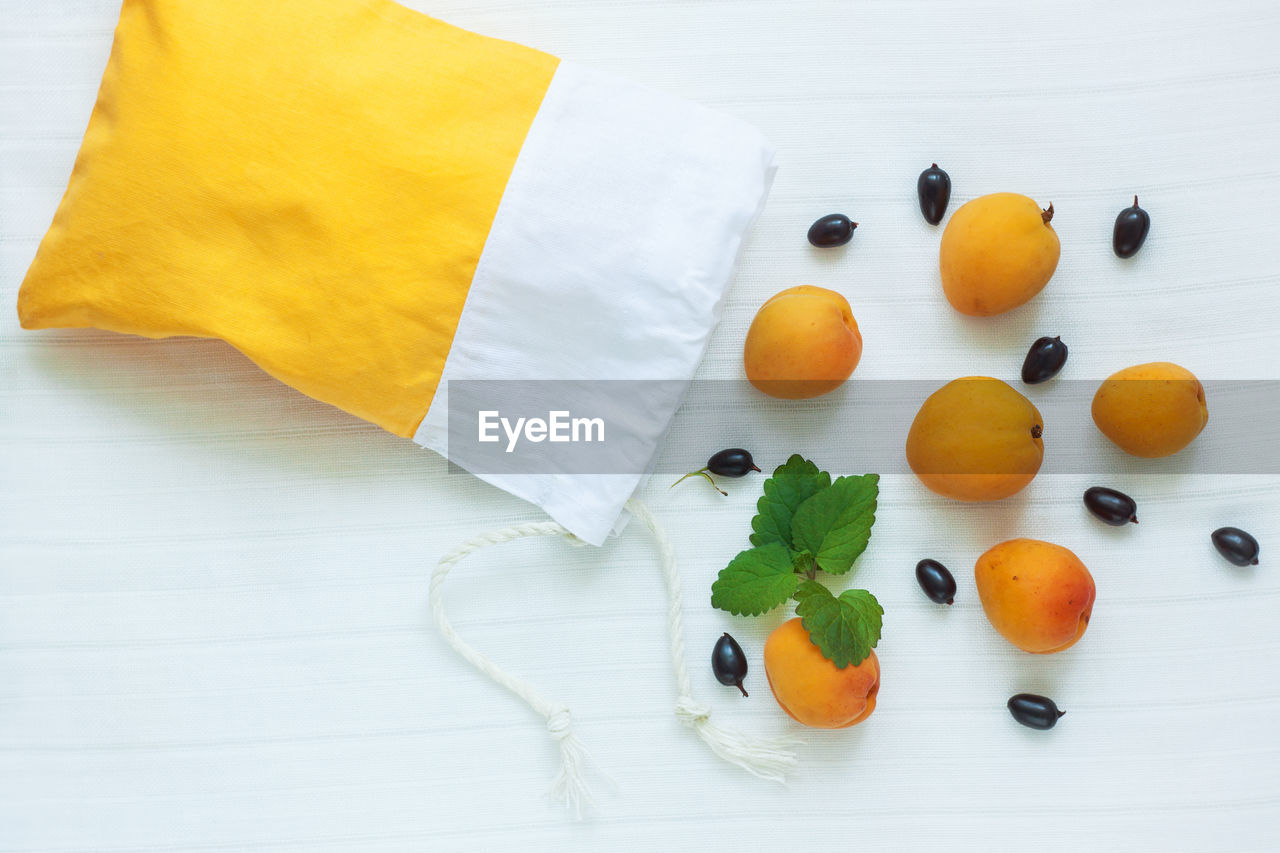 food and drink, food, healthy eating, fruit, wellbeing, yellow, freshness, high angle view, orange, orange color, no people, indoors, produce, citrus fruit, studio shot, still life, plant, table, copy space, textile, multi colored