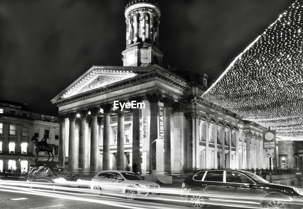 Blurred motion of cars on road against building at night