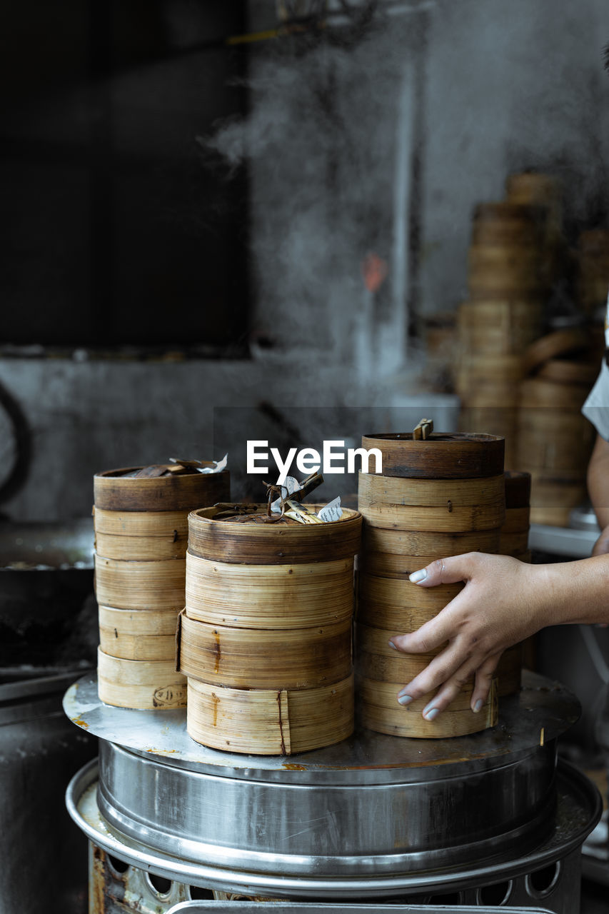 Cropped hand of woman stacking baskets in restaurant