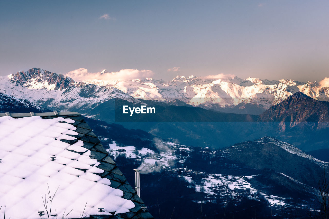 Aerial view of mountains against sky during winter