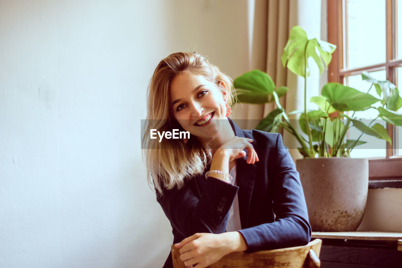 Portrait of smiling woman sitting at home