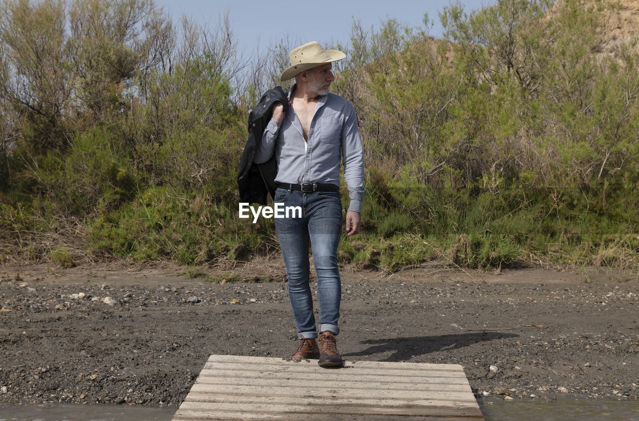 Adult man in cowboy hat in oasis of desert. almeria, spain