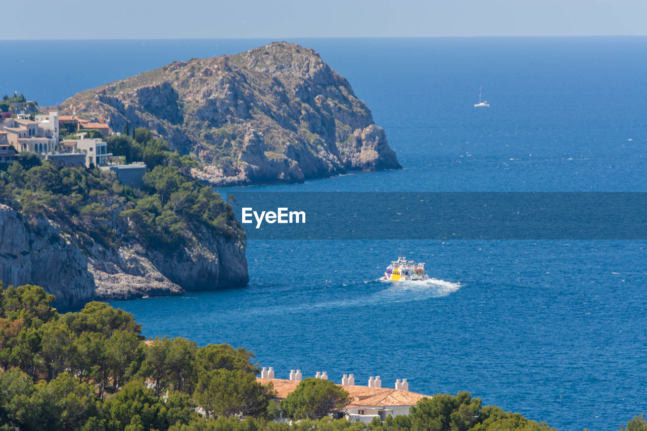 SCENIC VIEW OF SEA AGAINST MOUNTAINS