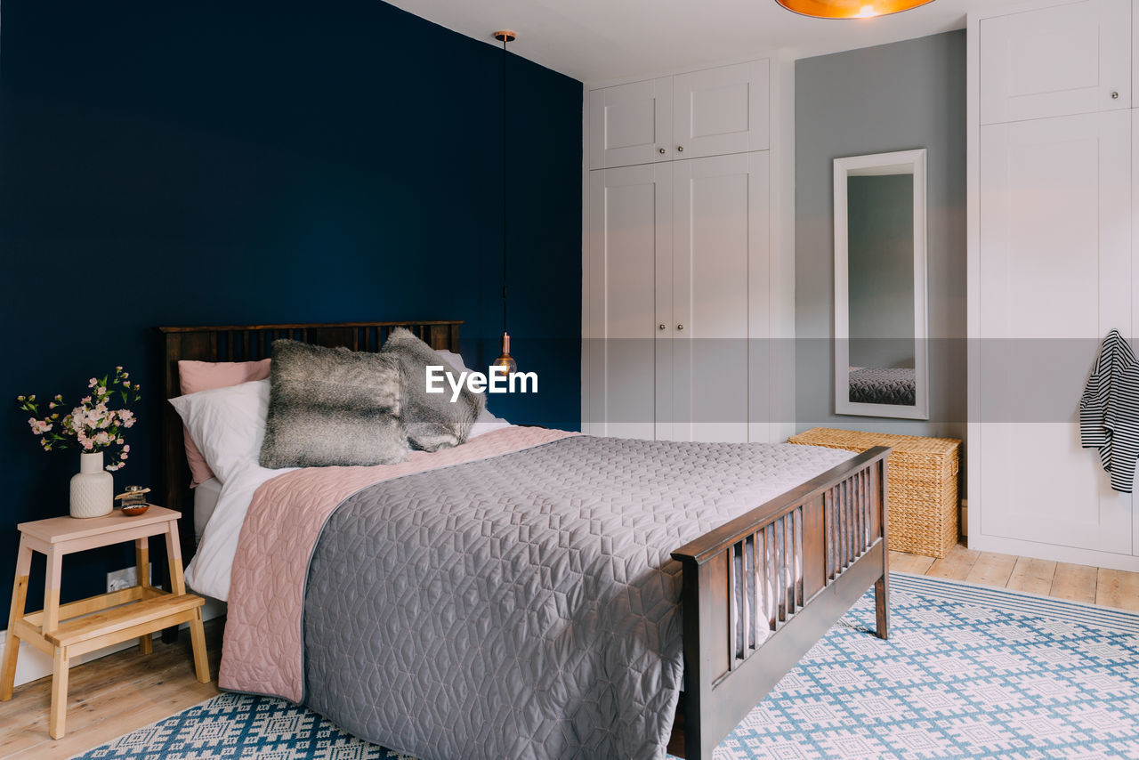 Bed by mirror and cabinet in bedroom