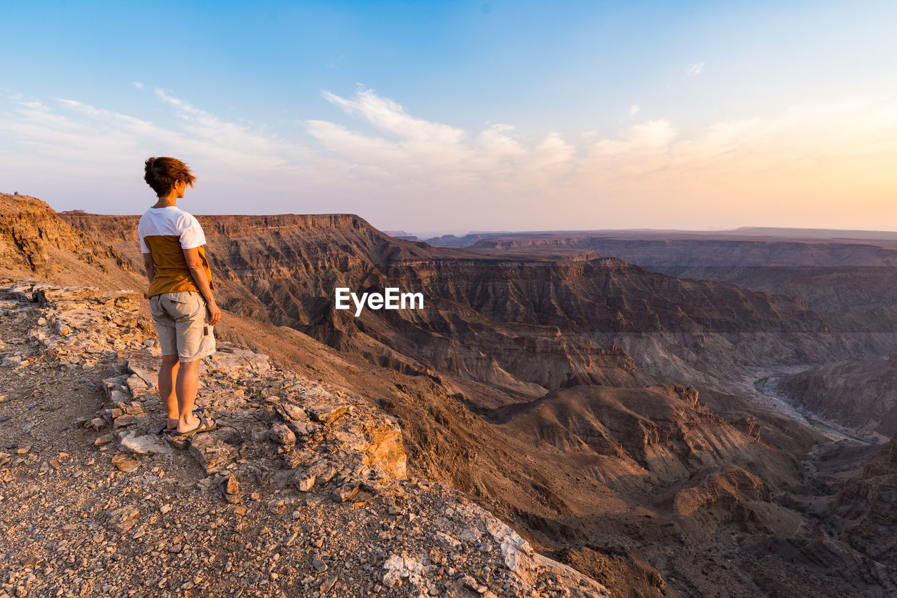 Woman standing on mountain against sky