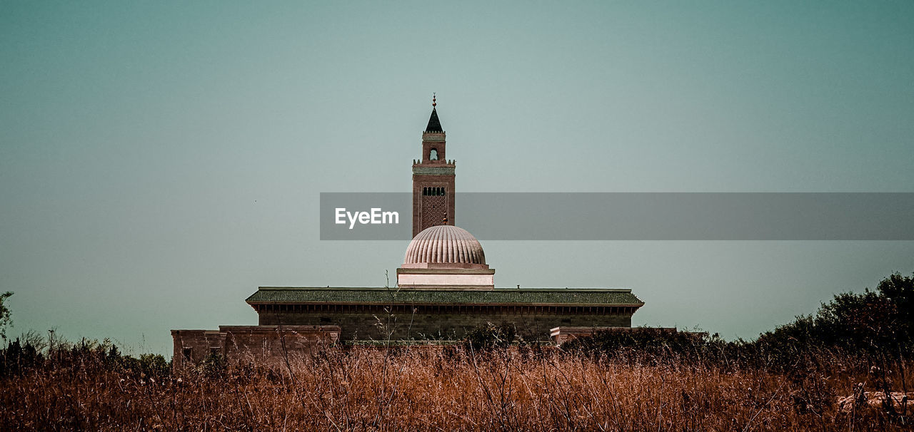 architecture, built structure, sky, building exterior, tower, nature, plant, building, religion, no people, travel destinations, evening, history, night, landmark, belief, the past, place of worship, tree, travel, outdoors, clear sky, spirituality, landscape, copy space, dusk, reflection