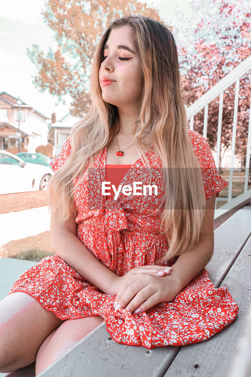 Beautiful young woman sitting on staircase