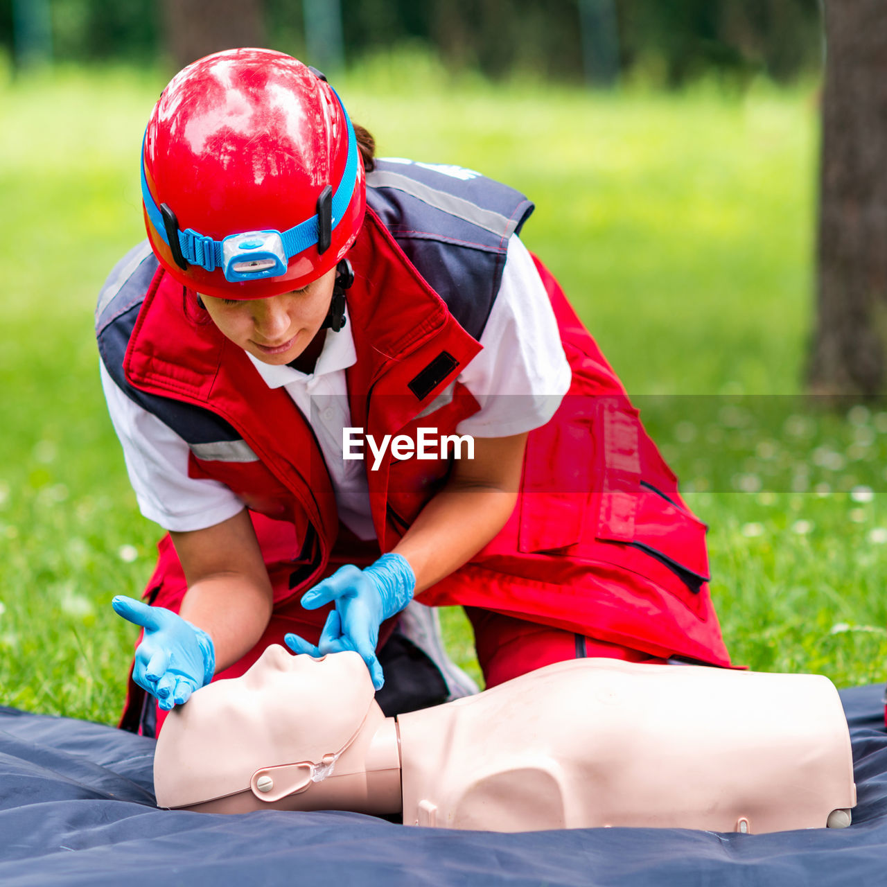 Healthcare worker practicing on cpr dummy at park