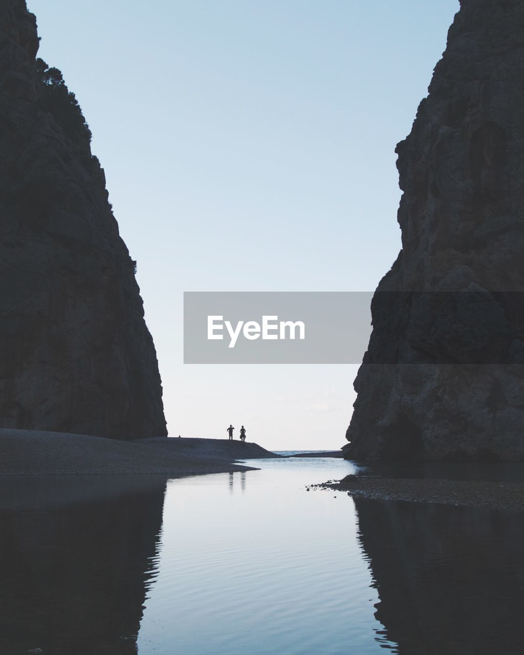 Rock formations at beach against clear sky