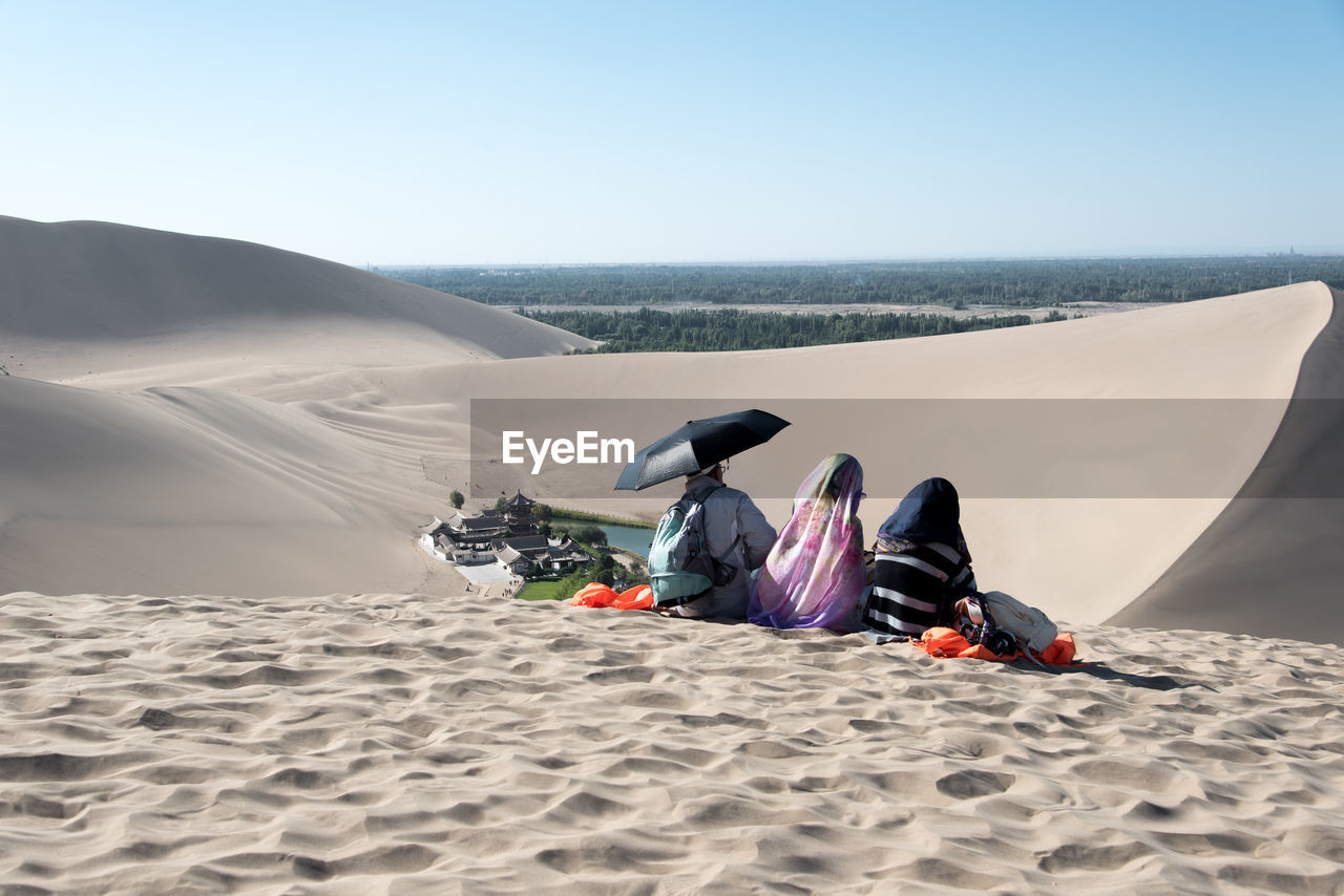 LOW SECTION OF PEOPLE ON SAND AT BEACH