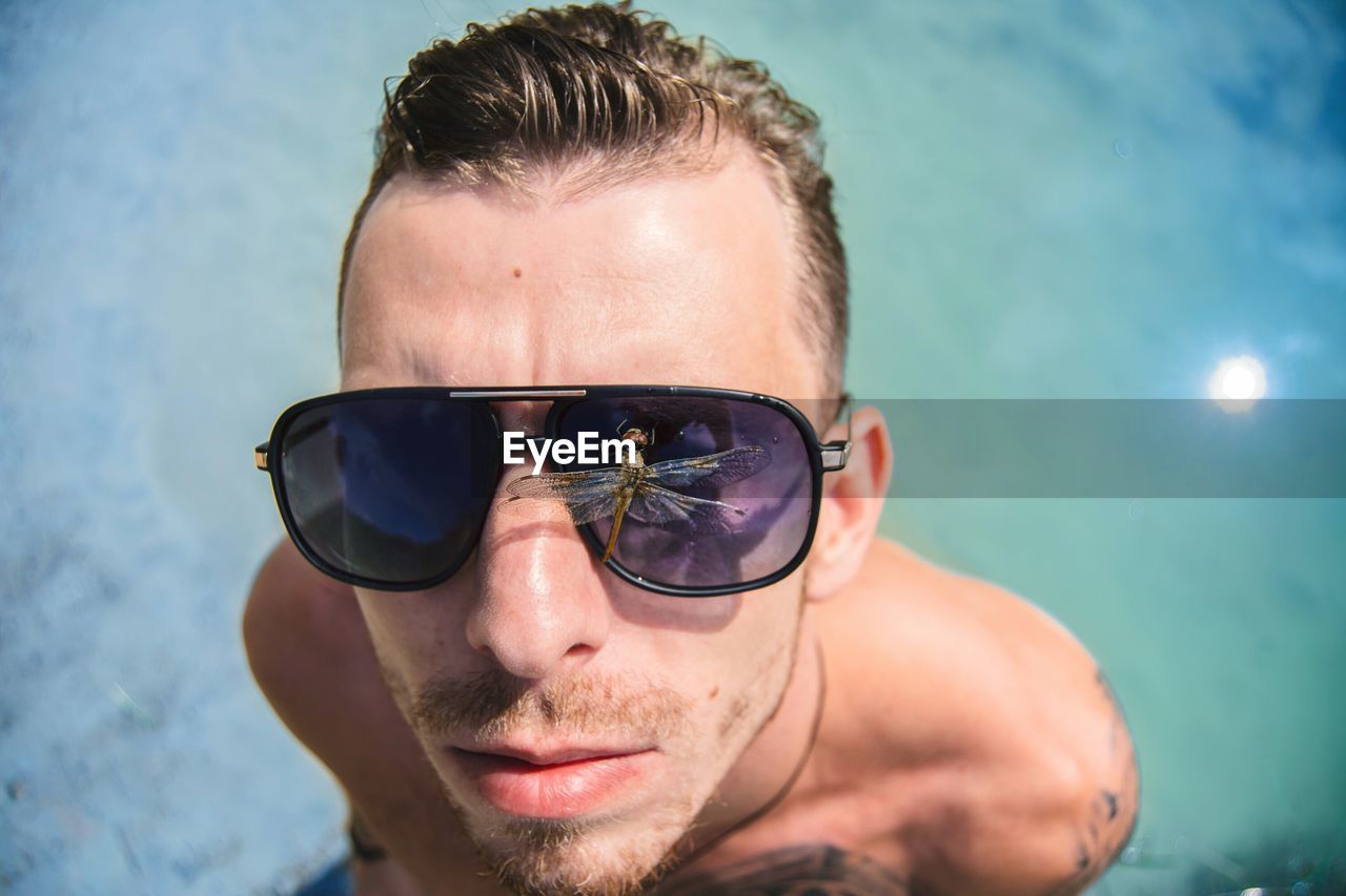 Portrait of young man wearing sunglasses against sky