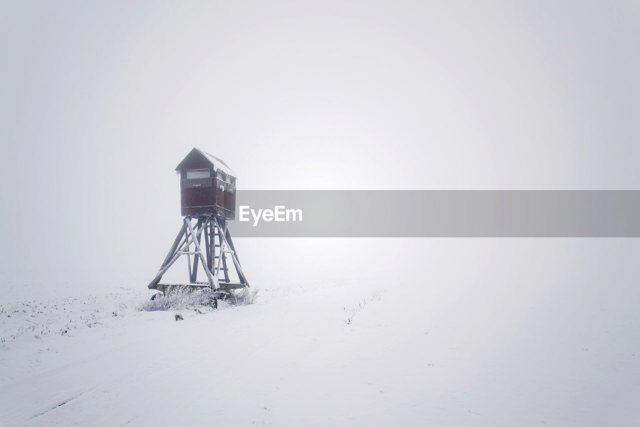 SNOW COVERED LAND AGAINST SKY DURING WINTER