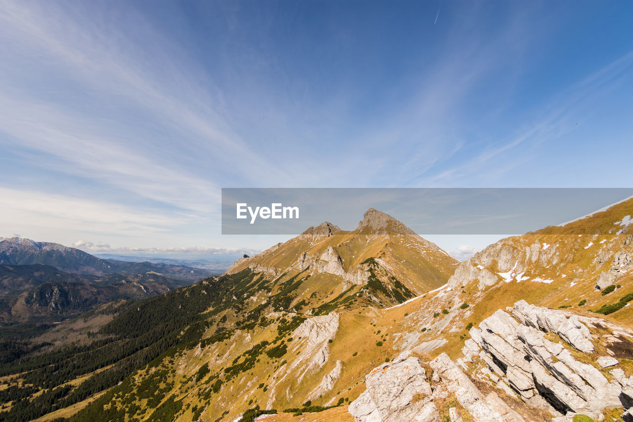 Scenic view of mountains against blue sky