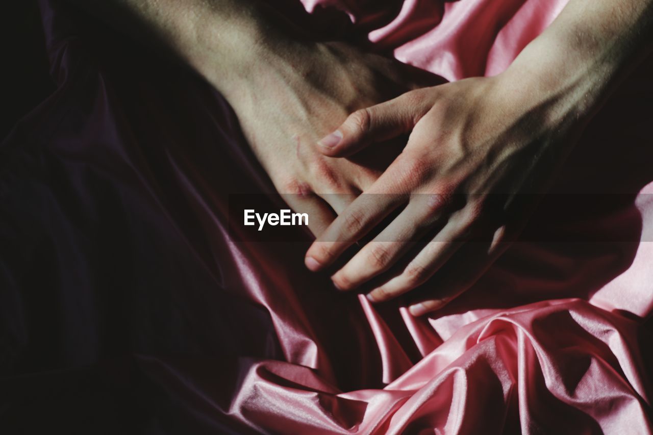 Cropped image of hands on pink textile