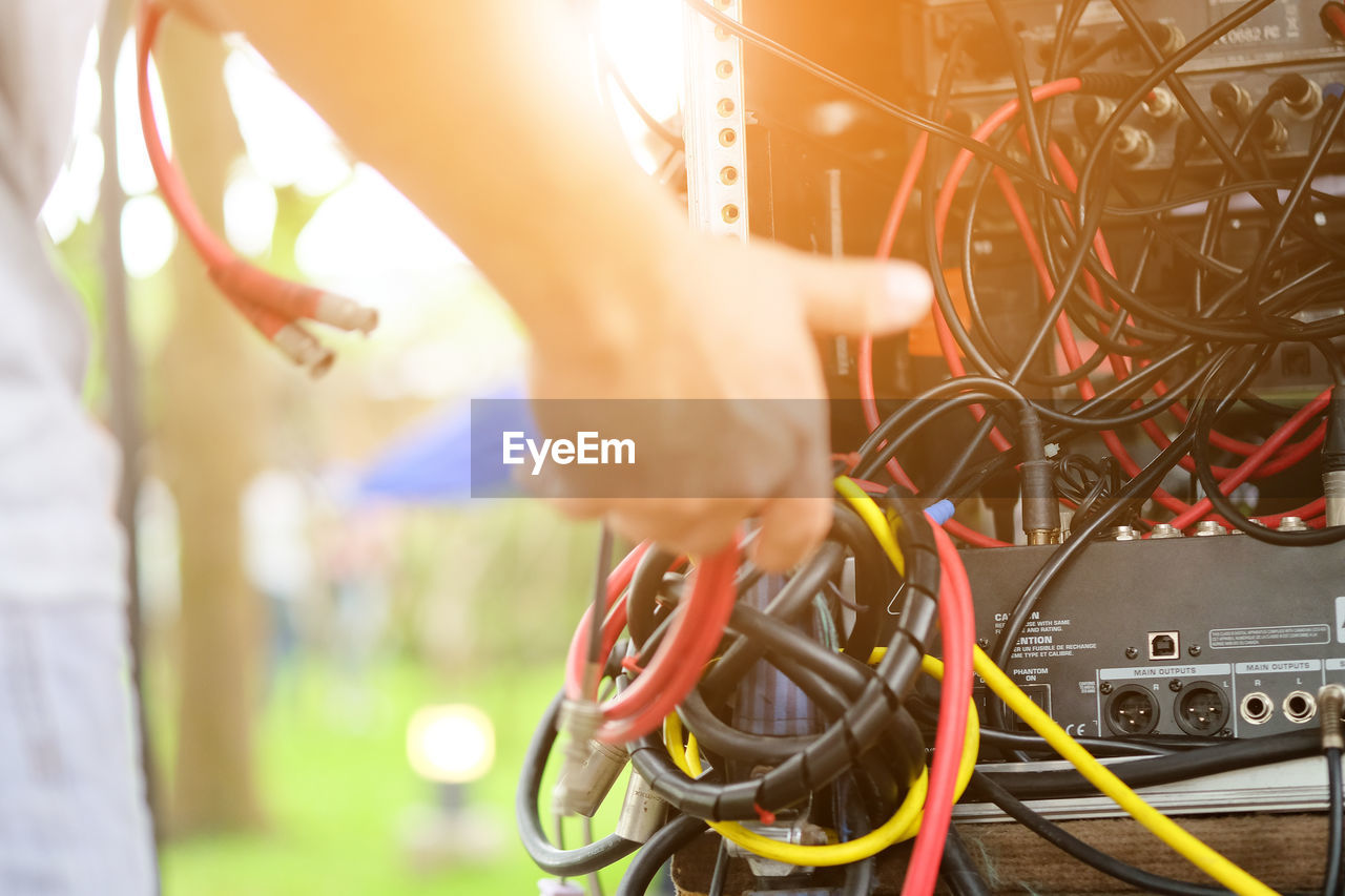 Close-up of man holding tangled cables of machinery