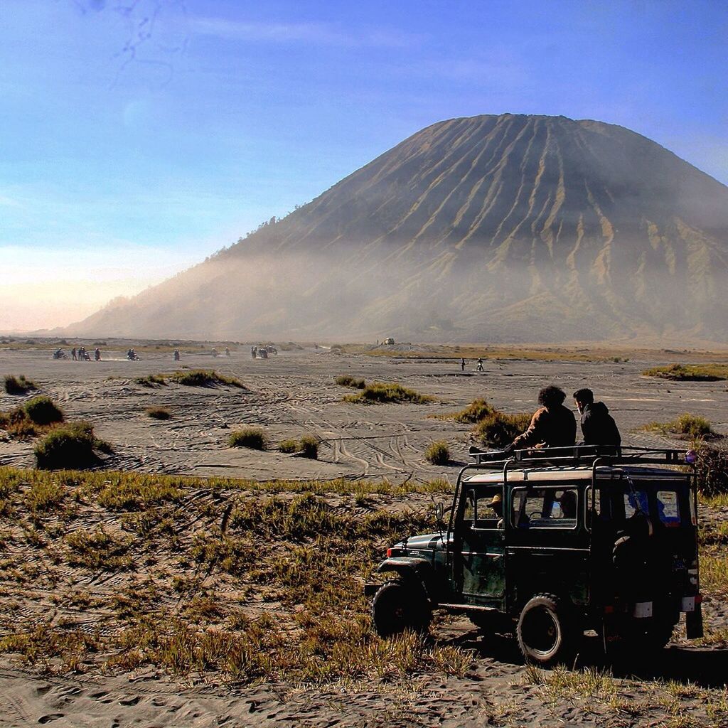 People in off-road vehicle against mt bromo