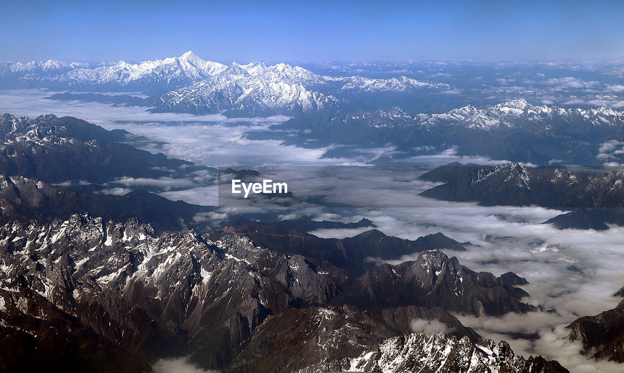 Scenic view of snowcapped mountains against sky among a sea of clouds, on the way to lhasa.