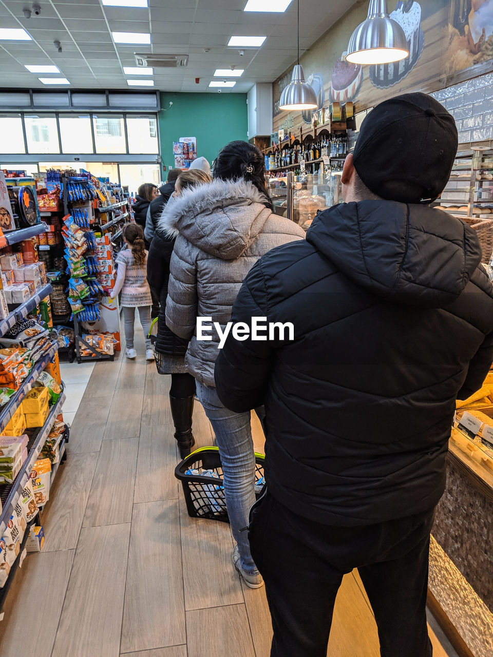 REAR VIEW OF PEOPLE AT STORE IN MARKET